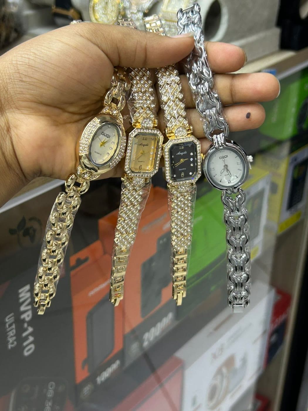 Four bracelet watches fanned across an open hand in the shop