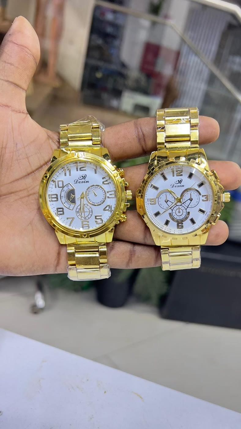 Two gold watches held up in the shop