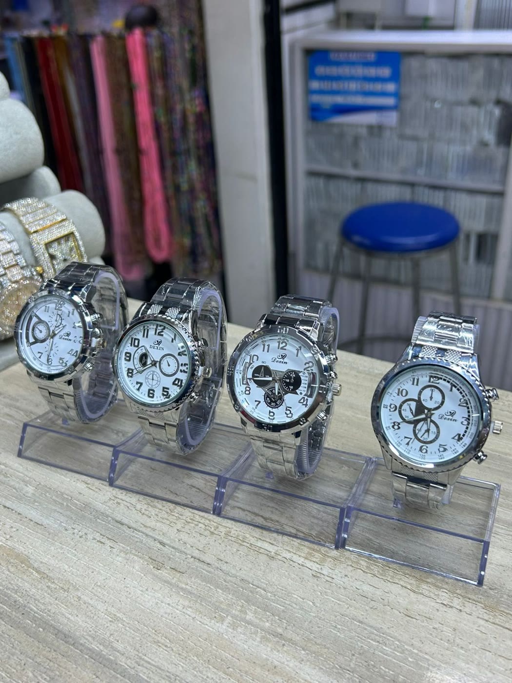 Watches lined up on clear stands on the shop counter
